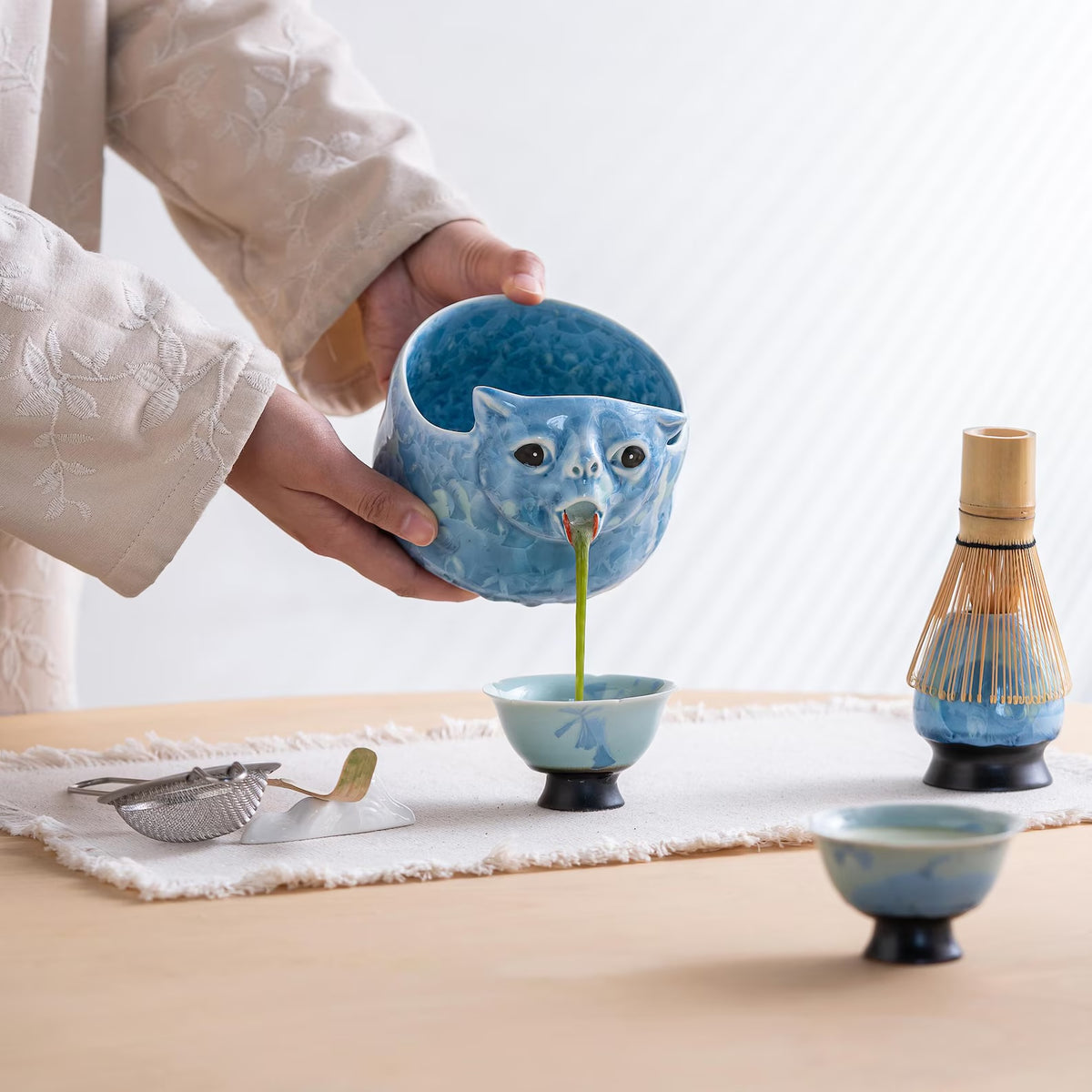 Pouring matcha from the Glacier Blue cat bowl