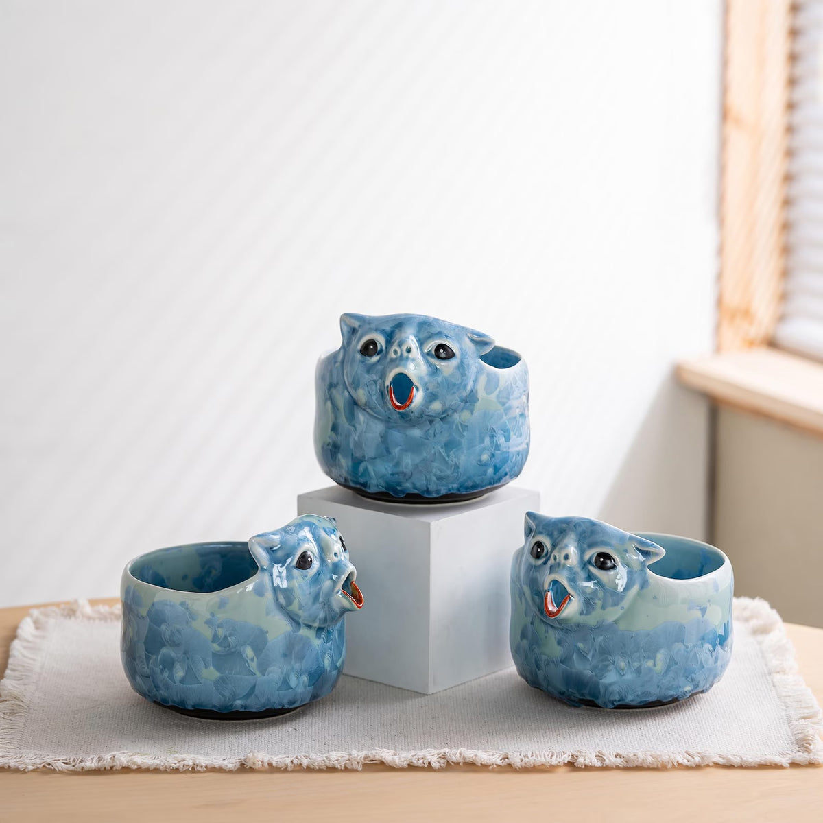 Three Glacier Blue cat bowls, each with a unique glaze pattern