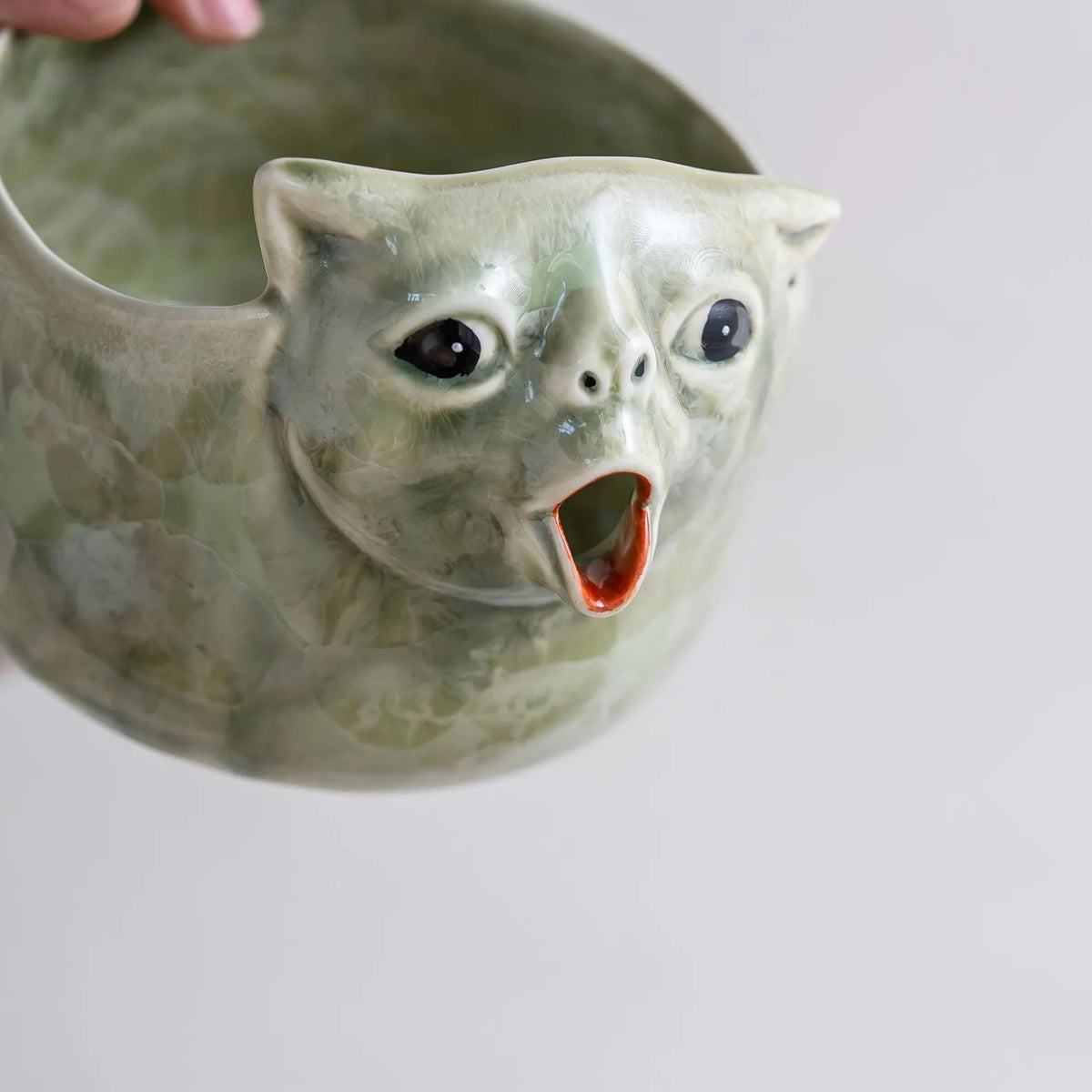 Close-up of the hand-sculpted cat face and crystal glaze