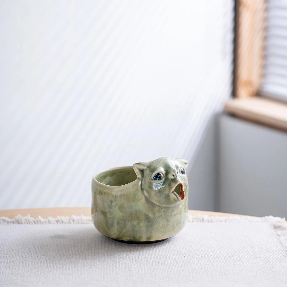 Celadon Green cat matcha bowl on a linen table runner