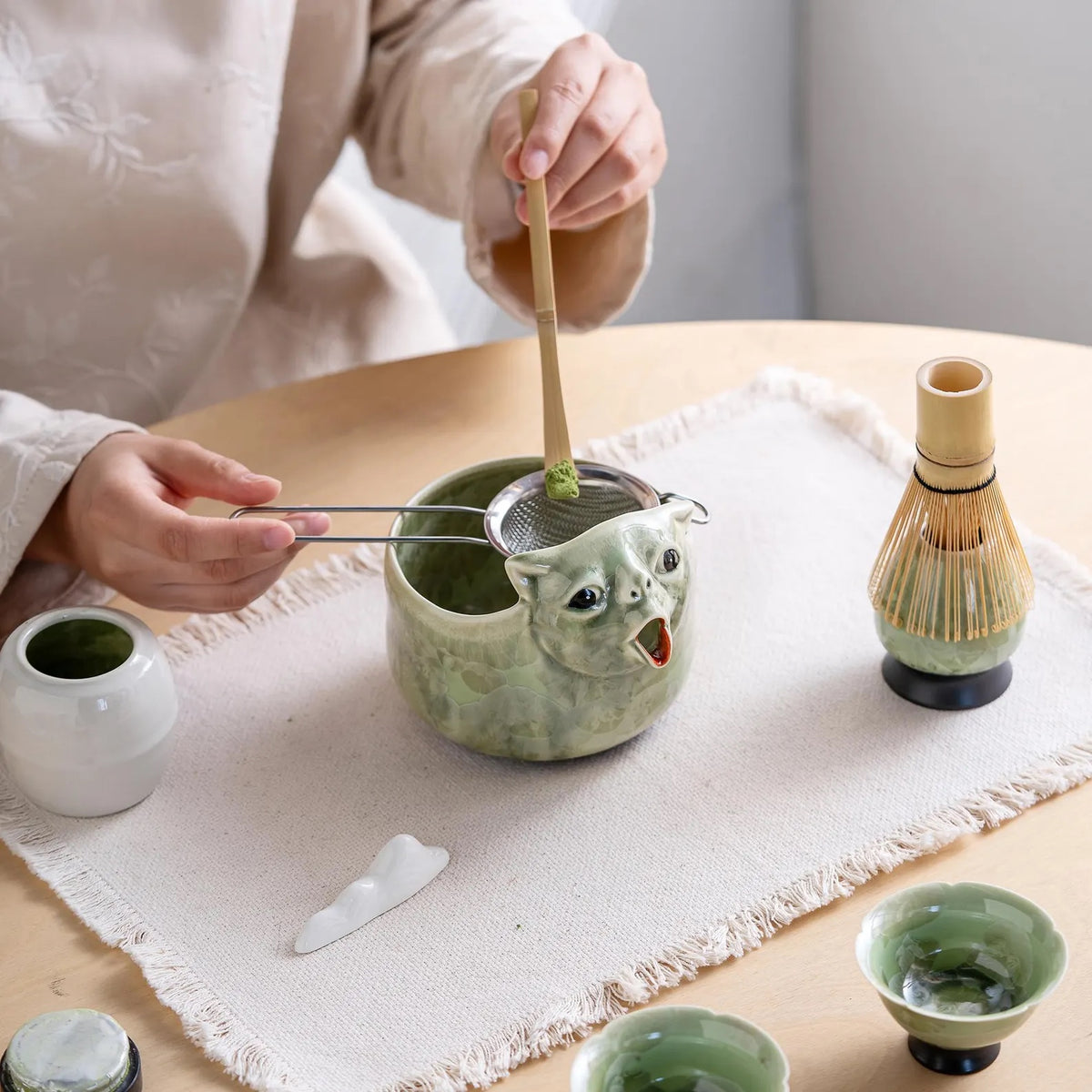 Sifting matcha into the Celadon Green cat bowl